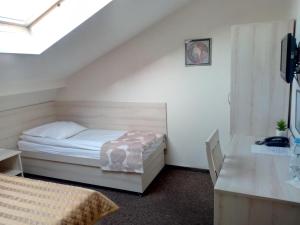 a bedroom with a white bed and white walls at Hotel Jester in Wrocław