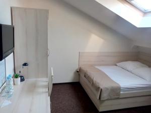 a bedroom with a white bed and white walls at Hotel Jester in Wrocław