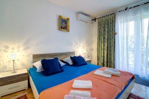 a bedroom with a blue and orange bed and a window at Apartments Diego in Sveti Juraj