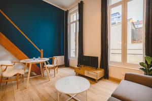 a living room with a table and a tv at Hyper centre - Hôtel de Ville in Reims