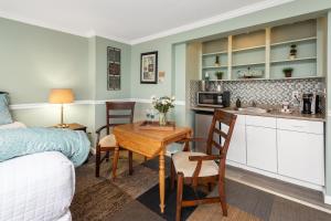 a kitchen and living room with a table and a bed at Nantasket Beach Hotel in Hull