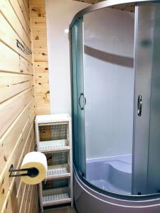 W łazience znajduje się prysznic ze szklanymi drzwiami. w obiekcie Domki Letniskowe MAJA w Pogorzelicy