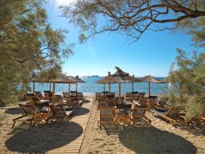 a bunch of chairs and tables on a beach at Bonatsa Beach House in Kimolos