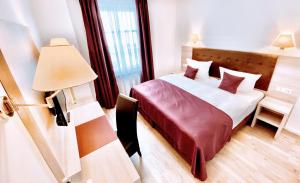 ein Hotelzimmer mit einem Bett und einer Lampe in der Unterkunft Das Hotel Krone in Königswinter