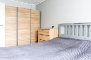 um quarto com uma cama e um armário de madeira em Good Place em Gdynia