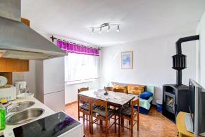 a kitchen and living room with a table and a stove at Apartments Diego in Sveti Juraj