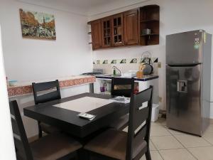 a kitchen with a black table and a refrigerator at Departamento Boulevard MZO in Manzanillo +8 photos