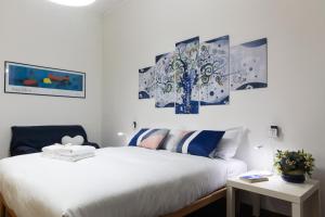 a bedroom with two beds and paintings on the wall at Albero Azzurro in Milan