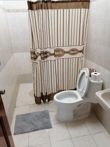 a bathroom with a toilet and a shower curtain at Departamento Boulevard MZO in Manzanillo