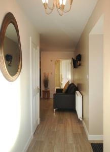 - un salon avec un canapé noir et un miroir dans l'établissement Machermore Castle East Lodge, à Newton Stewart