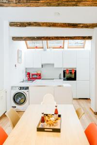 a kitchen with white cabinets and a table with food on it at Les Cerisiers - Duplex de Standing au Centre de Namur in Namur