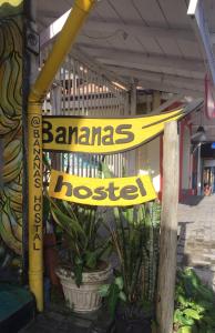 una pancarta amarilla en un poste frente a un edificio en BANANAS HOSTEL, en Itacaré
