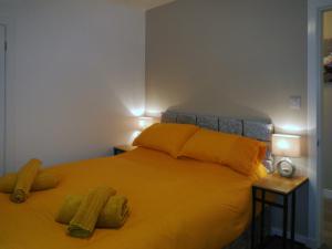 a bedroom with a large yellow bed with two lamps at Machermore Castle East Lodge in Newton Stewart