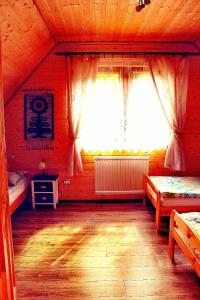 a bedroom with two beds and a large window at Stare Zabrodzie in Solina