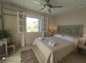 1 dormitorio con 2 camas y ventana en Porto Koundouros Beach and Villas, en Koundouros