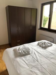 1 dormitorio con 1 cama blanca, vestidor y ventana en Vila Irina Kopaonik - Apartman Jovana, en Kopaonik