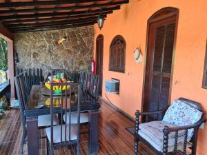 een tafel en stoelen op de veranda van een huis bij Suítes Casa do Barão in Búzios