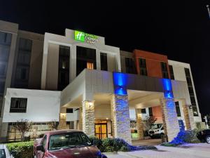 un hotel con un coche aparcado delante de él en Holiday Inn Express Hotel & Suites Dallas Fort Worth Airport South, an IHG Hotel, en Irving