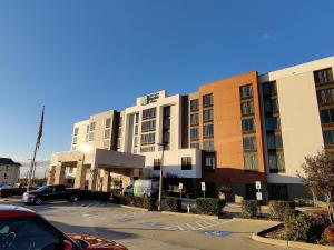 un parking en face d'un grand bâtiment dans l'établissement Holiday Inn Express Hotel & Suites Dallas Fort Worth Airport South, an IHG Hotel, à Irving