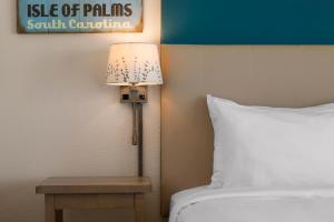 um candeeiro ao lado de uma cama num quarto de hotel em Seaside Inn - Isle of Palms em Isle of Palms