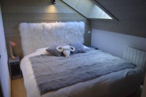 un animale di peluche su un letto in una stanza di Le lodge des Cîmes, Méribel Centre, Magnifique duplex cosy a Méribel