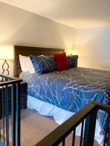 sypialnia z łóżkiem z niebieską kołdrą i poduszkami w obiekcie The Palace Hotel w mieście Port Townsend