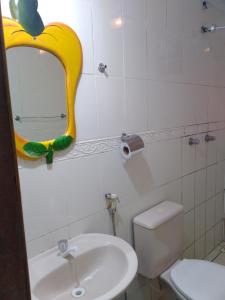 a bathroom with a sink and a mirror on the wall at Pousada Tropical (Adults Only) in Marituba