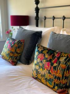 uma cama com duas almofadas e uma almofada floral em The Clock House em Chichester