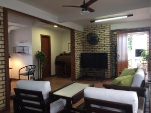 a living room with a couch and a tv at Apartamentos Morada do Canto - 130m da praia principal Bombinhas in Bombinhas