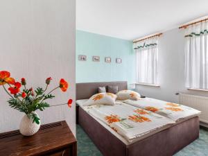 ein Schlafzimmer mit einem Bett und einer Vase mit Blumen in der Unterkunft Apartment in Lichtenhain with mountain views in Lichtenhain