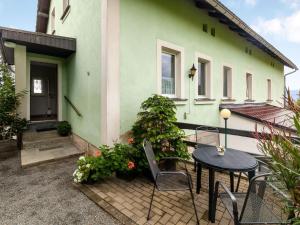 una casa verde con una mesa y sillas frente a ella en Apartment in Lichtenhain with mountain views, en Lichtenhain