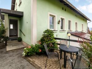 ein grünes Haus mit einem Tisch und Stühlen davor in der Unterkunft Apartment in Lichtenhain with mountain views in Lichtenhain