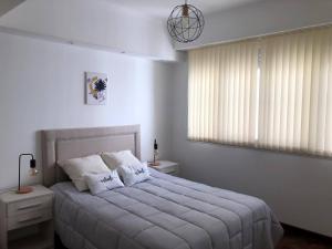 a white bedroom with a large bed with white pillows at Plaza Colon in Mar del Plata