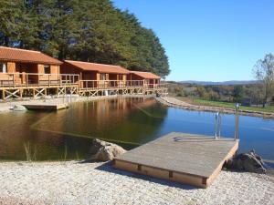 a log cabin with a dock in the water at Parque Biologico de Vinhais in Vinhais