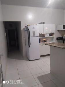 een keuken met een witte koelkast in de kamer bij Casa Pirineus in Pirenópolis