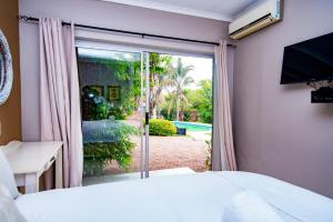 1 dormitorio con ventana y vistas a la piscina en Hutten Heights Lodge by Ilawu, en Newcastle
