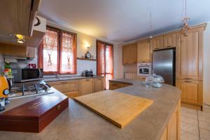uma cozinha com armários de madeira e um frigorífico de aço inoxidável em CASA NEL RUSTICO Foresteria Lombarda em Misinto