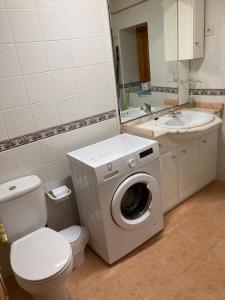 a bathroom with a washing machine and a sink at Casa Encuentra, en el Pirineo al lado de Ainsa in El Pueyo de Araguás