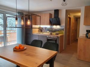 kuchnia i jadalnia z drewnianym stołem w obiekcie Alpen Appartements Viehhofen - incl Sommercard Zell am See Viehhofen w mieście Viehhofen