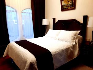 - une chambre avec un lit doté de draps blancs et une fenêtre dans l'établissement Hotel Boutique La Albertina, à San Martín Texmelucan de Labastida