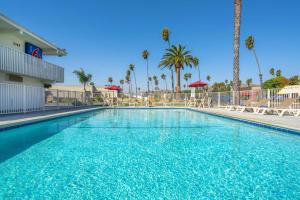 a swimming pool at a resort with palm trees at Motel 6-Ventura, CA - Beach in Ventura