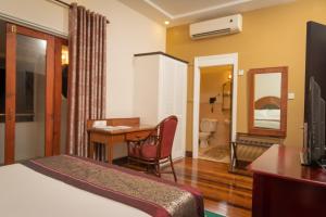 a hotel room with a bed and a desk and a bedroom at Herdmanston Lodge Hotel in Georgetown