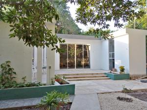 梅里達的住宿－Casa Del Aire，白色的房子,设有玻璃门和楼梯