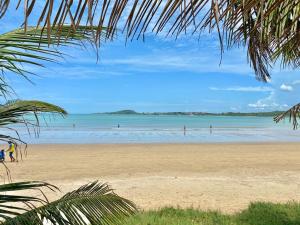 a beach with people playing in the water at Pousada Santa Monica in Guarapari