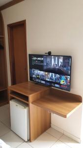 a desk with a flat screen tv on a wall at Golden Dolphin Caldas Novas in Caldas Novas