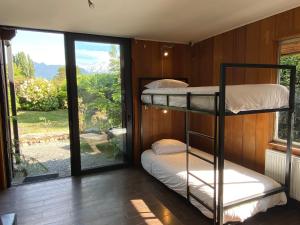 a room with two bunk beds and a window at French Andes Apart Hostel in Pucón