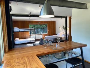 um quarto com uma mesa e 2 beliches em French Andes Apart Hostel em Pucón