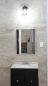 W łazience znajduje się umywalka i lustro. w obiekcie Hotel Itza Coba w mieście Cobá