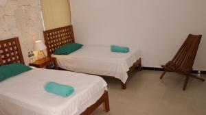 a room with two beds and two chairs at Hotel Itza Coba in Cobá