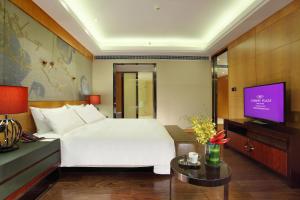 Crowne Plaza Chengdu West, an IHG Hotel في تشنغدو: غرفة فندق بسرير وتلفزيون